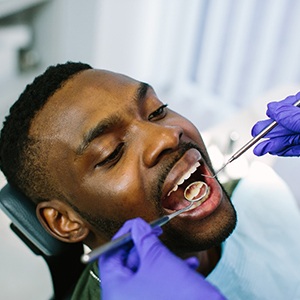 A young man receiving a dental checkup from his dentist