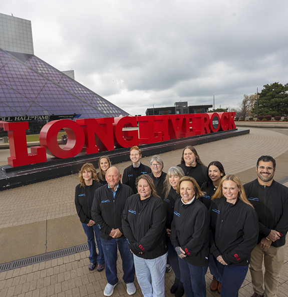 Rocky River Dental team smiling in front of the Rock and Roll Hall of Fame